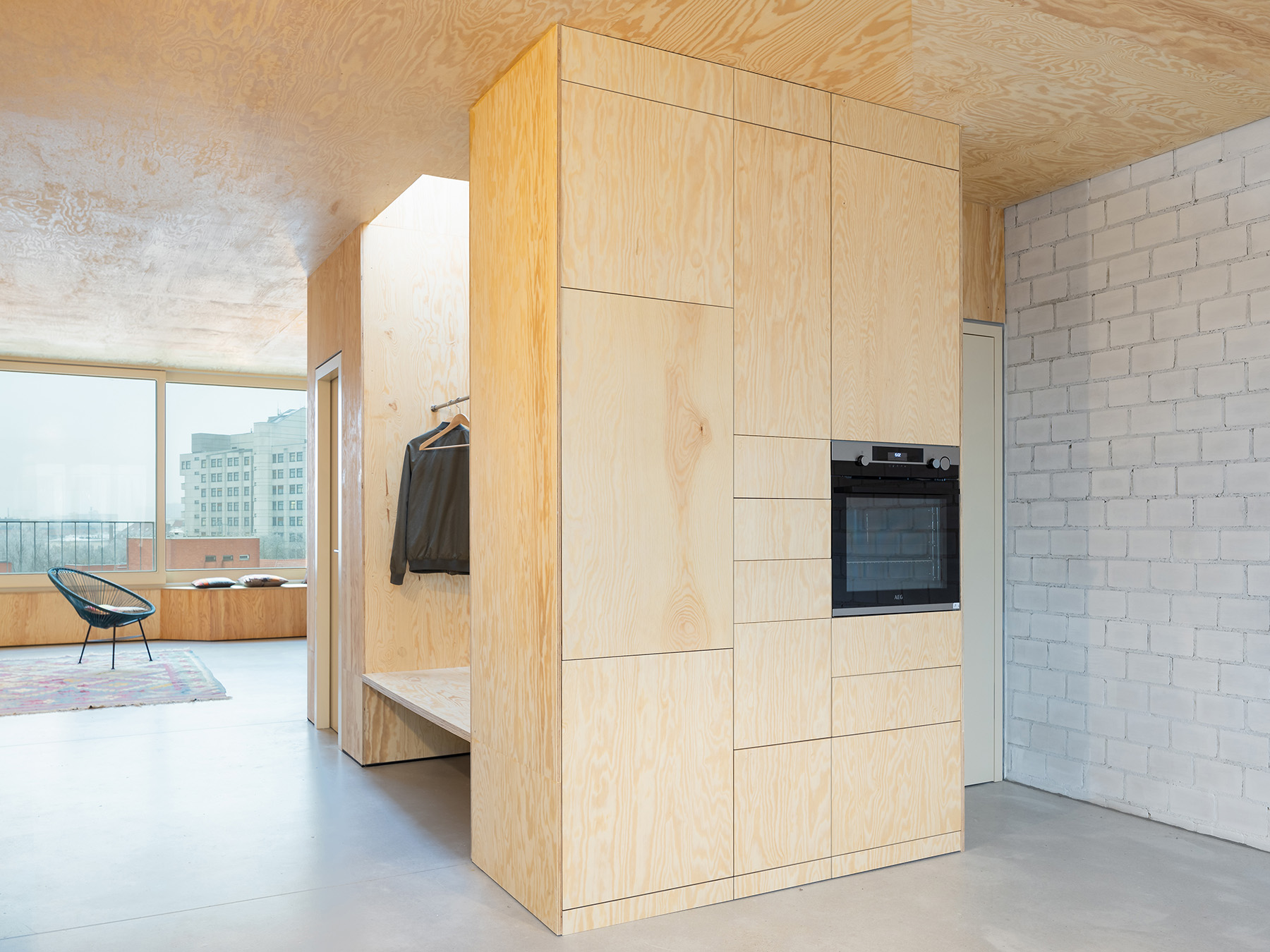 Ausgebauter Dachstuhl mit Einbaumöbeln aus Holz und Sichtestrich für den Boden