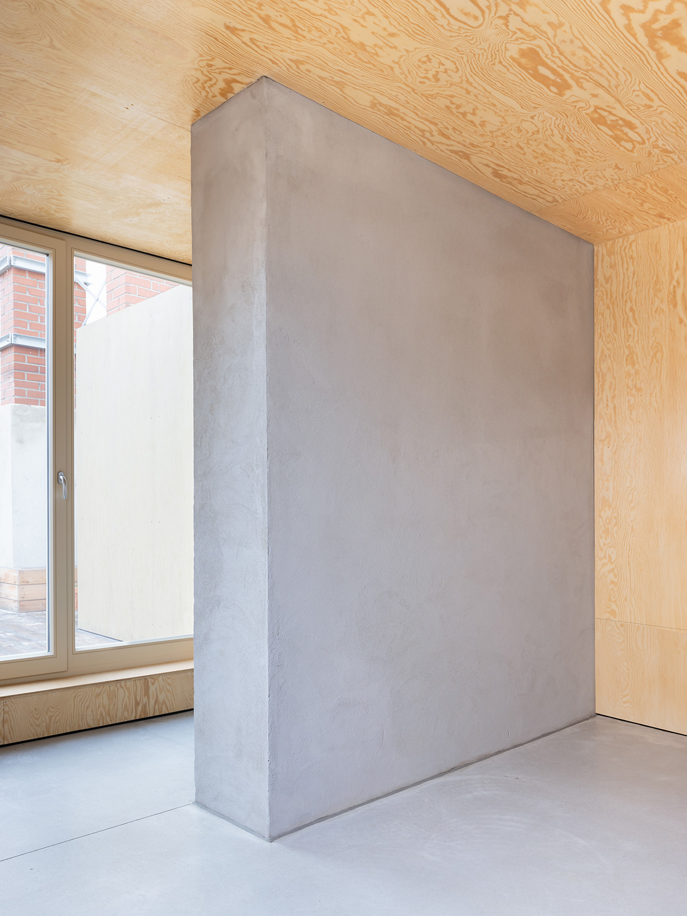 Ausgebauter Dachstuhl mit neuer Trennwand in Beton und Boden aus Sichtestrich