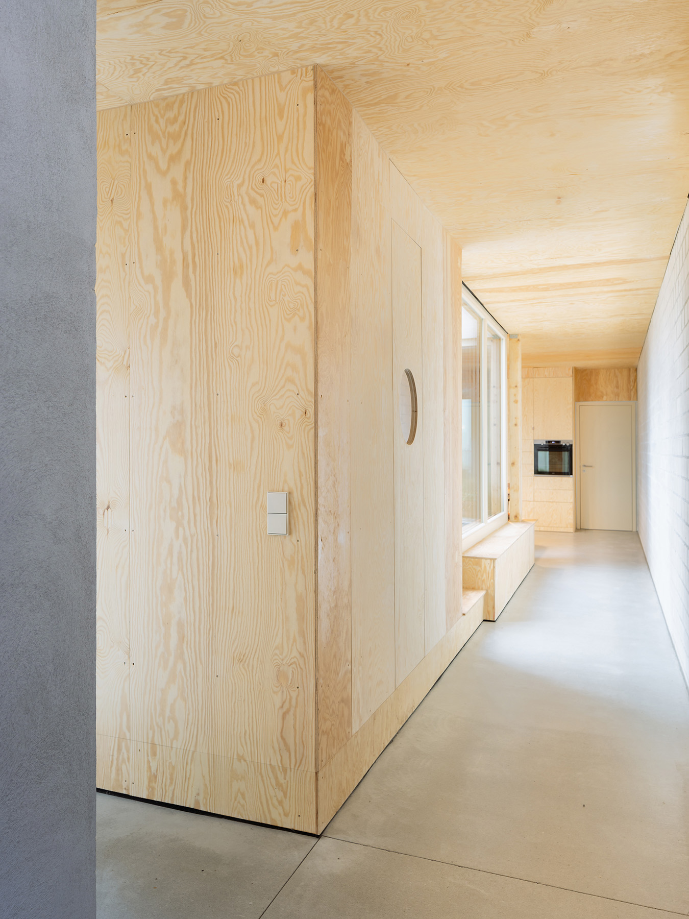 Ausgebauter Dachstuhl mit Einbaumöbeln aus Holz und Sichtestrich für den Boden