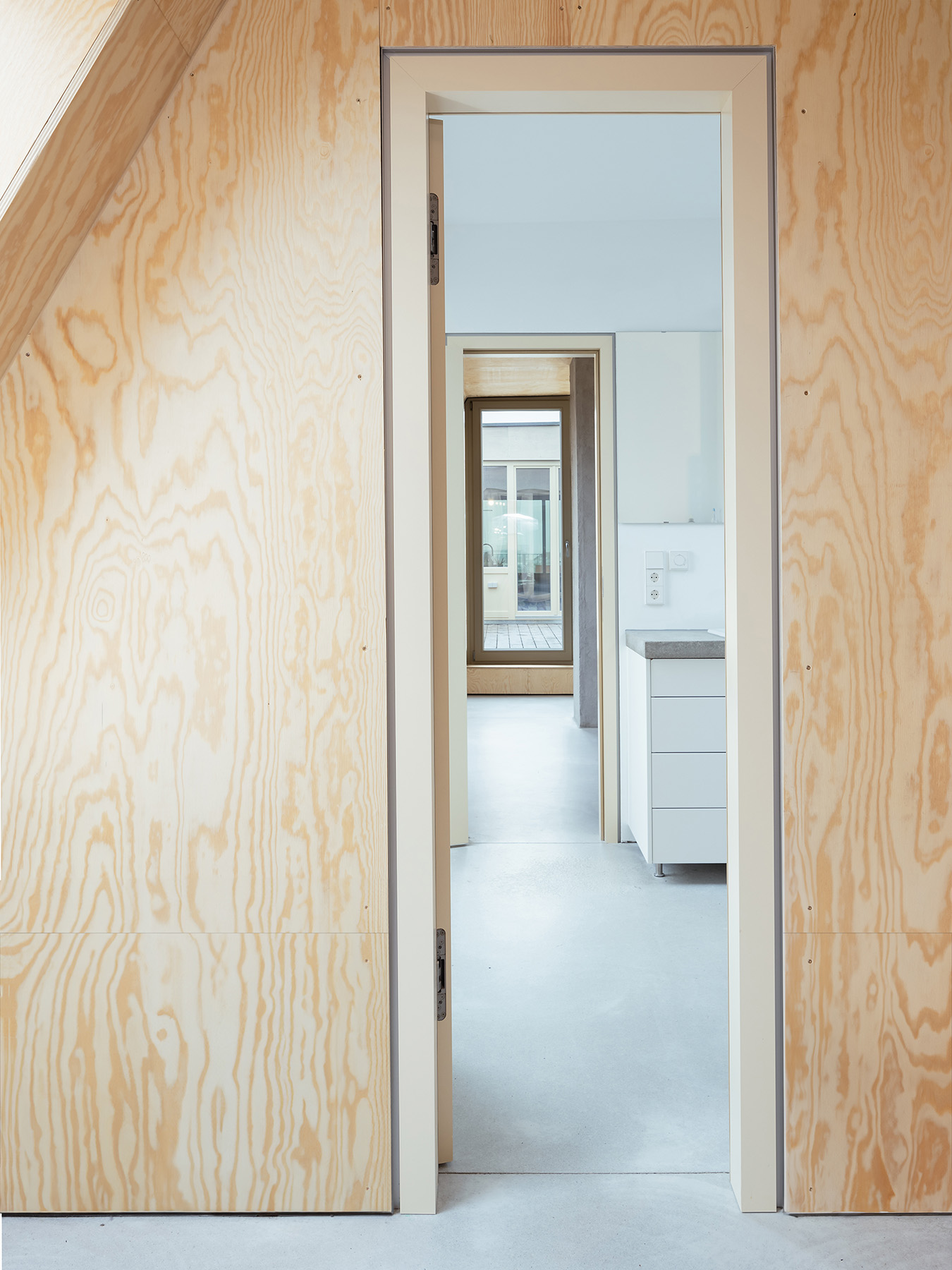 Ausgebauter Dachstuhl mit Einbaumöbeln aus Holz und Sichtestrich für den Boden