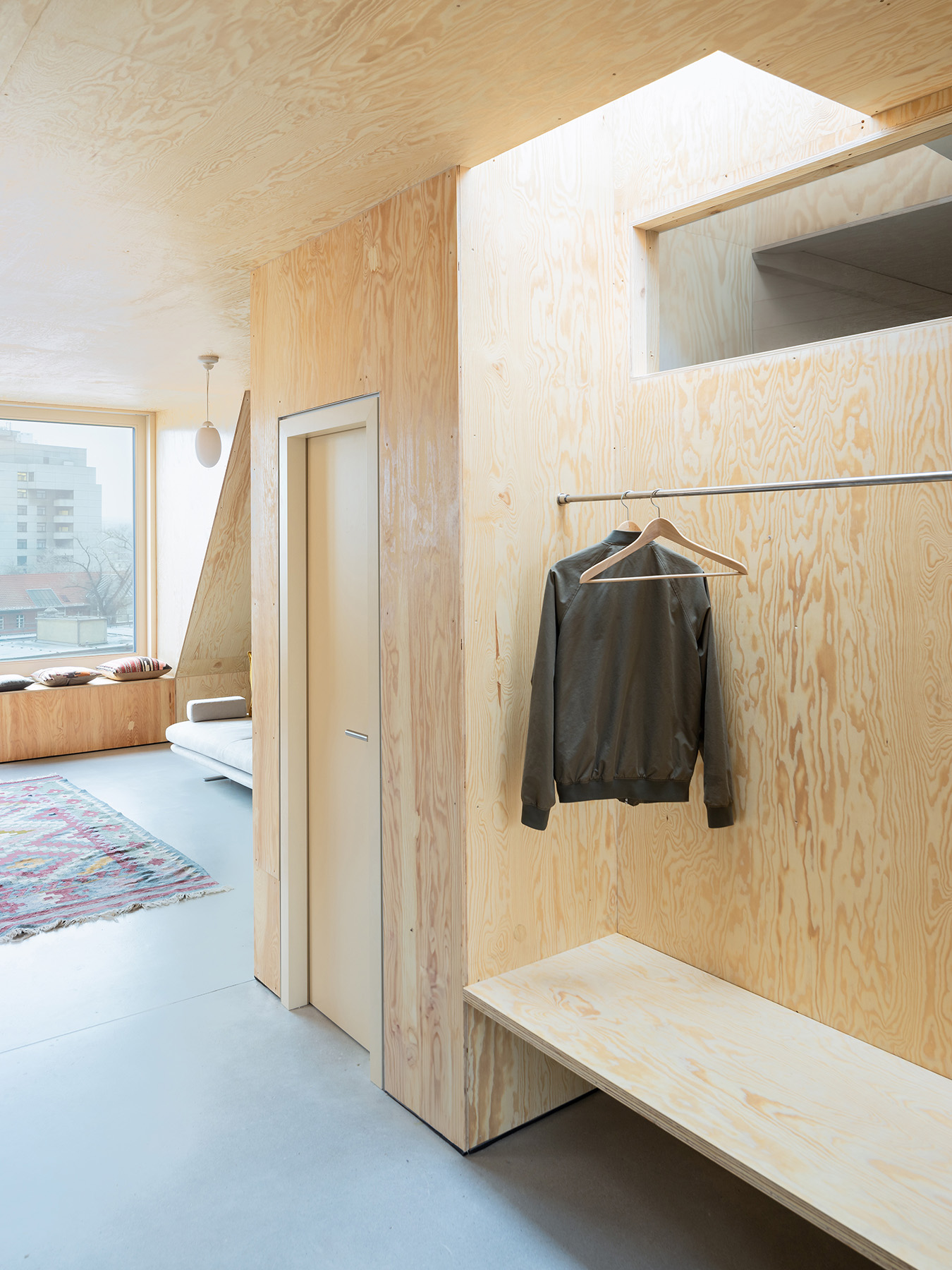 Ausgebauter Dachstuhl mit Einbaumöbeln aus Holz und Sichtestrich für den Boden