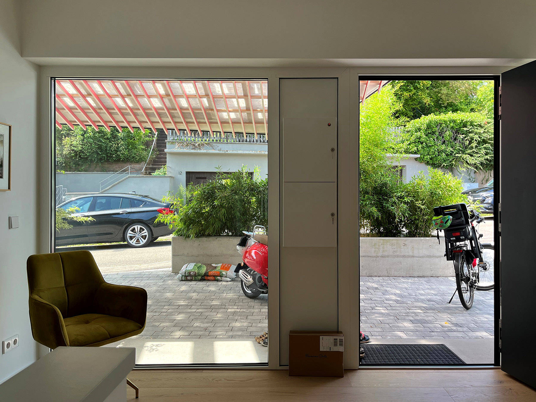 Vorfahrt mit transluzenter Überdachdung und rosa Holzlamellen und Gasziegeln 