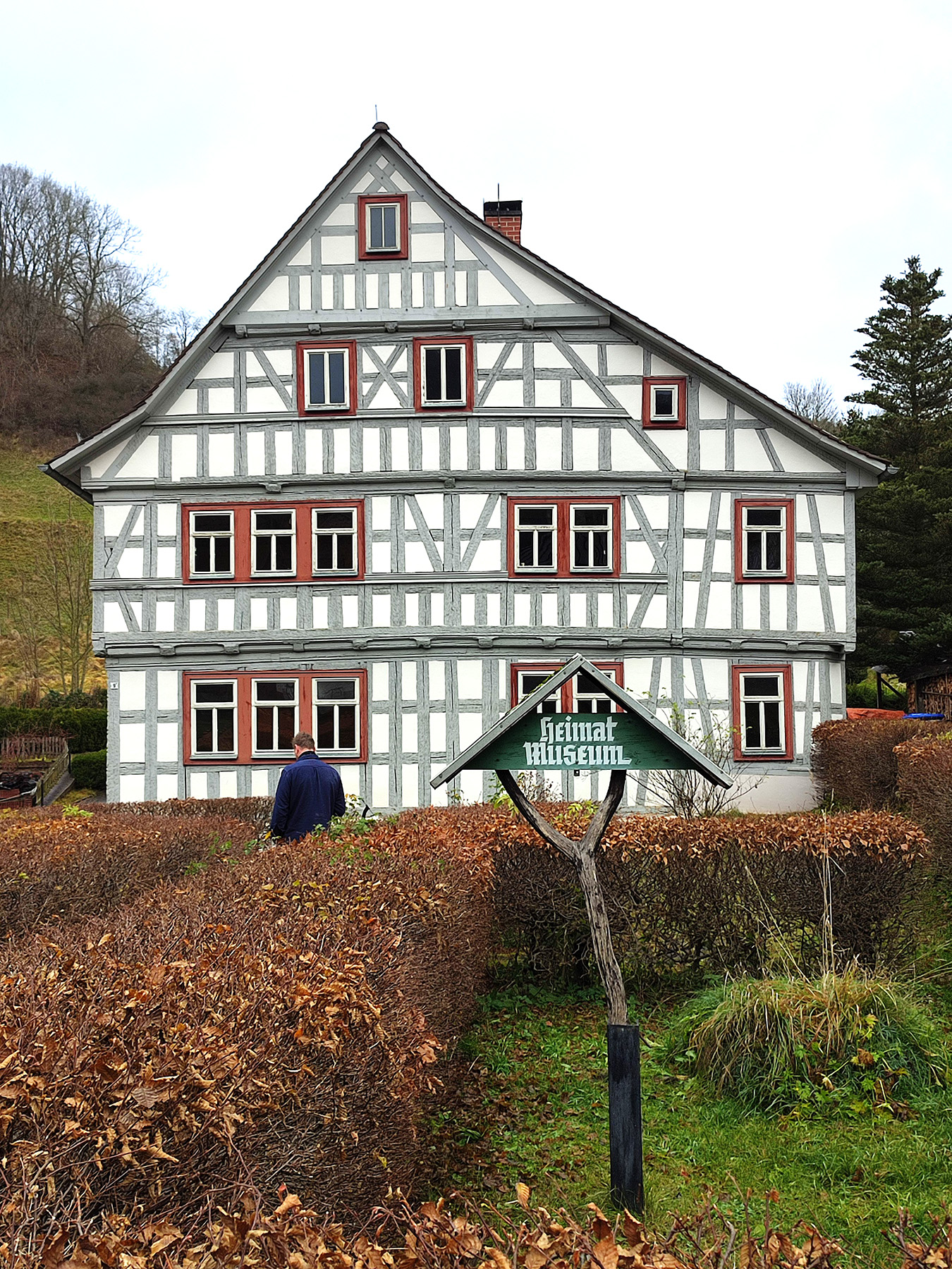 Fachwerkhaus mit hellgraum Fachwerk und Hecken im Vordergrund