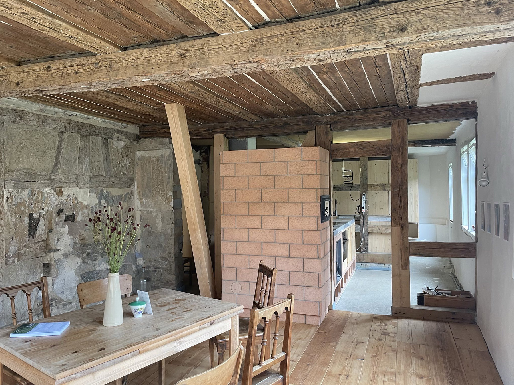 Raum in einem Fachwerkhaus mit sichtbaren Holzbalken und Stielen und einem roten Kamin