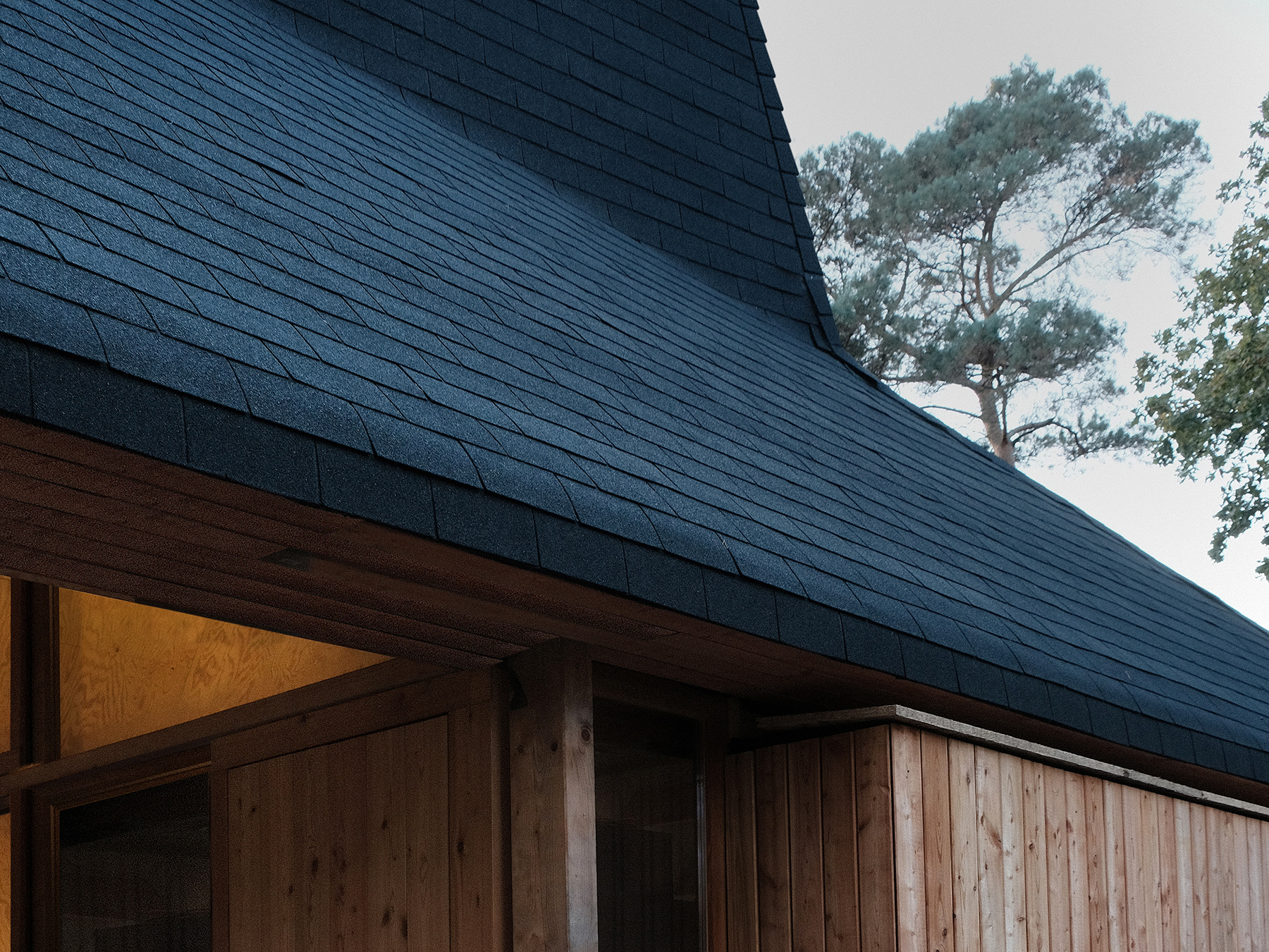 Übergang eines gewölbten Daches zu den Holzwänden