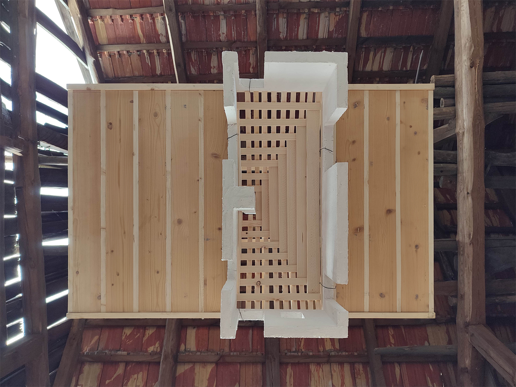 Holzmodell das an Schnüren in einer alten Scheune hängt